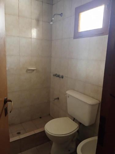 a bathroom with a toilet and a shower with a window at Casa de campo in Uspallata