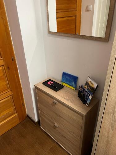 a wooden dresser in a room with a mirror at DiSte Apartman in Knin