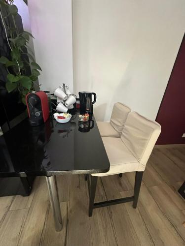 a table with a white chair and a black table at Loft 11 personnes Sauna Jacuzzi in Mouscron