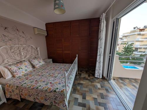Un dormitorio con una cama y una gran puerta corrediza de vidrio. en Family apartment mountain and sea, en Atenas