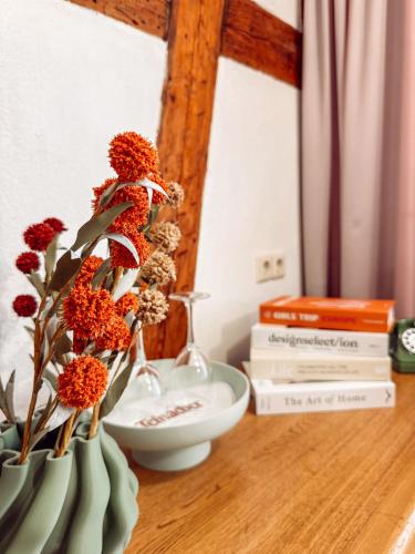 two vases with flowers on a table with books at Hotel Restaurant Ratsstube in Calw