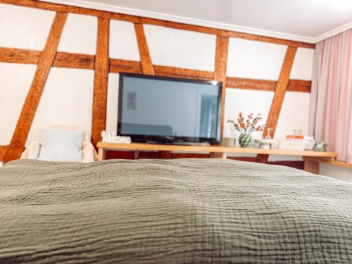 a bedroom with a bed and a flat screen tv at Hotel Restaurant Ratsstube in Calw