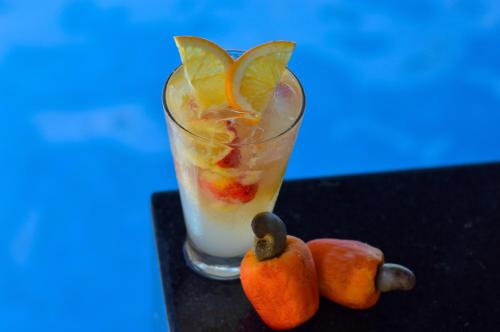 a drink with fruit in a glass on a table at Hotel Solar Porto de Galinhas in Porto De Galinhas