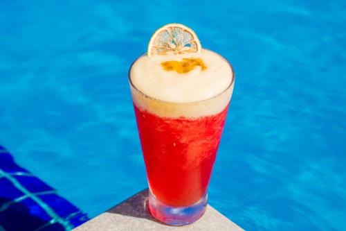 a red drink with a lemon slice on top at Hotel Solar Porto de Galinhas in Porto De Galinhas