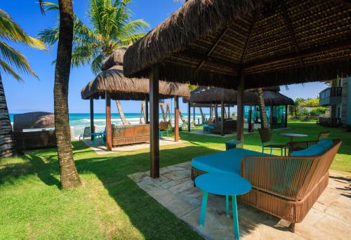 a restaurant with a blue table and chairs and the beach at Hotel Solar Porto de Galinhas in Porto De Galinhas