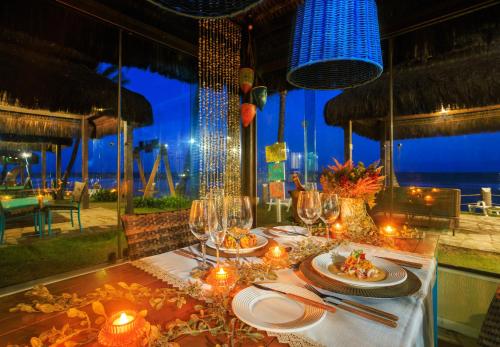 a table with plates of food on it with a view of the ocean at Hotel Solar Porto de Galinhas in Porto De Galinhas