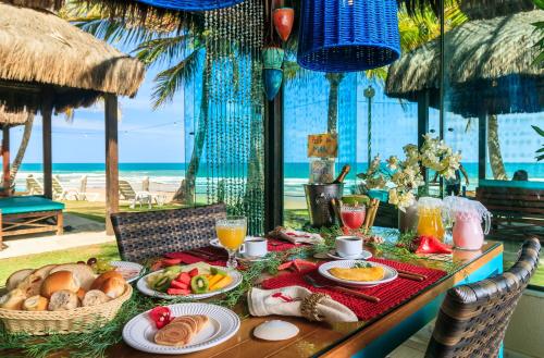 a table with food and a view of the beach at Hotel Solar Porto de Galinhas in Porto De Galinhas