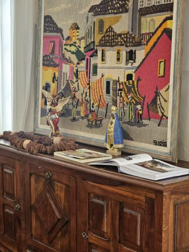 a dresser with a painting on top of it at Hotel Barbacena in Barbacena