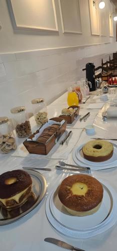 a table topped with plates of cakes and desserts at Hotel Barbacena in Barbacena