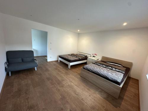 a room with two beds and a couch and a chair at Große 2 Ferienwohnung Gästehaus NEUBAU Merzig 100 m2 in Merzig