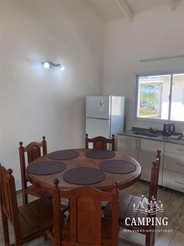 a kitchen with a table and chairs and a refrigerator at Cabañas Camping Malvinas Argentinas in Paso de la Patria