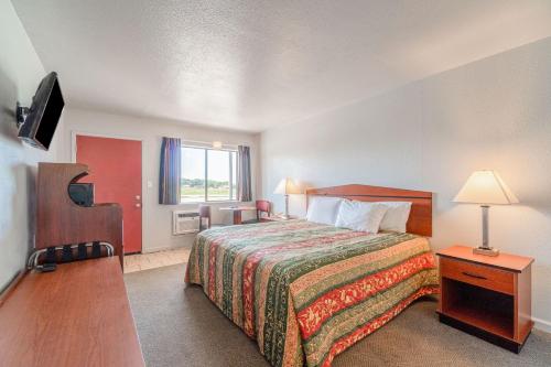 a hotel room with a bed and a window at Capital O Aurora Inn Monett US 60 in Aurora