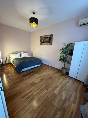 a bedroom with a bed and a wooden floor at Apartment near Meidling in Vienna