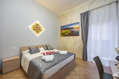 a bedroom with a bed and a table and a window at Marea B&B in Gioiosa Marea