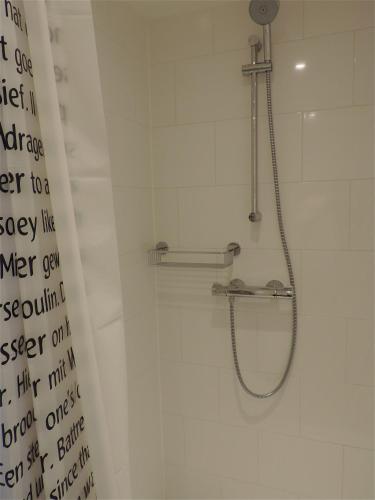 a shower in a bathroom with a shower curtain at Sea & Dunes in Scheveningen