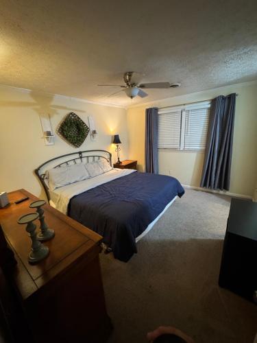 a bedroom with a bed with a blue bedspread at Middle of It All only 30 min from Mammoth Cave! in Bowling Green