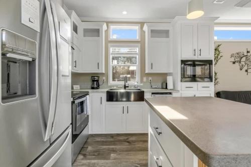 a kitchen with white cabinets and a stainless steel refrigerator at Byrd 6 Cozy Byrd Nest in Owens Cross Roads