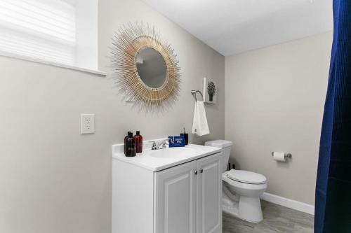 a white bathroom with a toilet and a mirror at Dugan Ave Unit B in Owenton