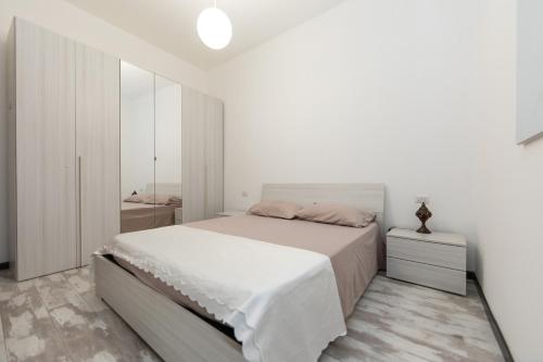 a white bedroom with a bed and a mirror at Relax in Ladispoli 500m from the sea and 20 minutes from Rome in Ladispoli