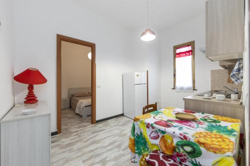 a bedroom with a bed and a kitchen with a table at Relax in Ladispoli 500m from the sea and 20 minutes from Rome in Ladispoli