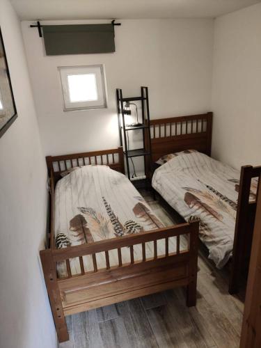 two twin beds in a room with a window at Béke Tanya in Nyársapát