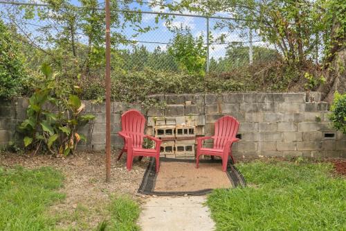 two red chairs and a table in a yard at 12th Ave The Bricks - Unit 1 in Birmingham