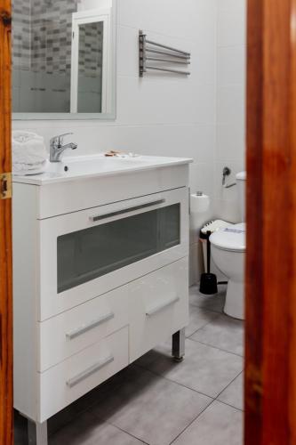 a white bathroom with a sink and a toilet at Estancia - Bungalow en Puerto Rico in Puerto Rico de Gran Canaria