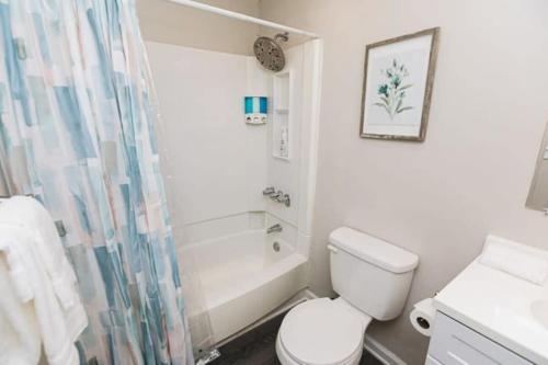 a white bathroom with a toilet and a shower at 47th Place Forest Park in Mountain Brook