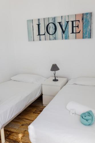 two beds in a room with a sign that reads hope at Estancia - Bungalow en Puerto Rico in Puerto Rico de Gran Canaria