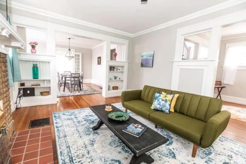 a living room with a green couch and a table at 29th Street Trendy Lakeview Craftsman 8 in Birmingham