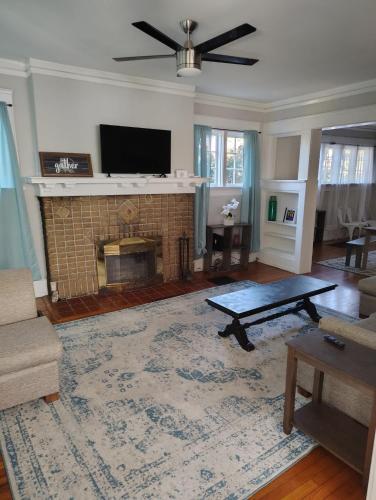 a living room with a fireplace and a tv at 29th Street Trendy Lakeview Craftsman 8 in Birmingham