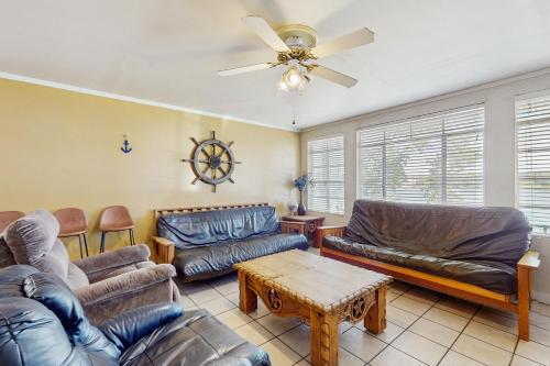 a living room with leather furniture and a ceiling fan at Sunny Days Lake Retreat - Main house in Kingsland