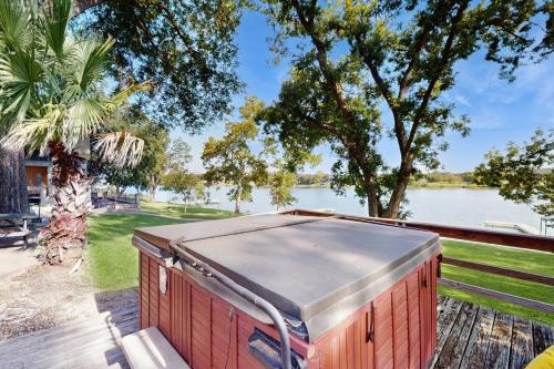 a red container sitting on a table next to a body of water at Sunny Days Lake Retreat - Main house in Kingsland