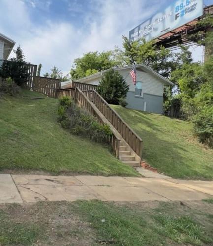 a house with a fence and a staircase in a yard at 12th Ave The Bricks - Unit 7 in Birmingham