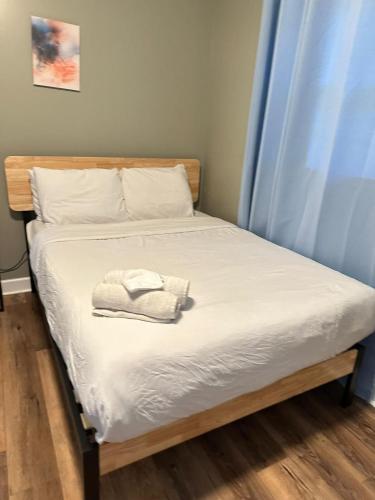 a bed with white sheets and a towel on it at Bethany B Huntsville Oasis in Rideout Village