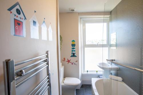 ブリクサムにあるHarbour View- Cosy Maisonette, Close to Brixham Harbourのトイレ、洗面台、窓のあるバスルーム