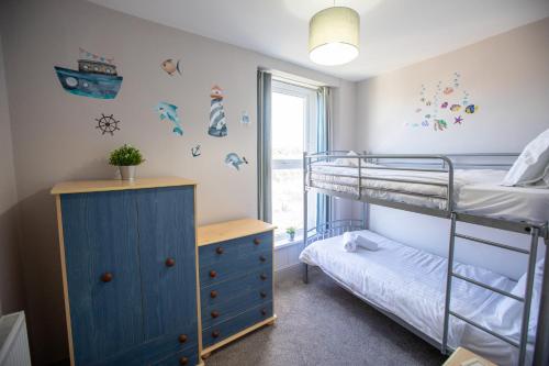 ブリクサムにあるHarbour View- Cosy Maisonette, Close to Brixham Harbourの二段ベッド2台と窓のある寝室