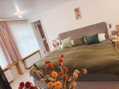 a bedroom with a large bed and a vase with flowers at Hotel Restaurant Ratsstube in Calw
