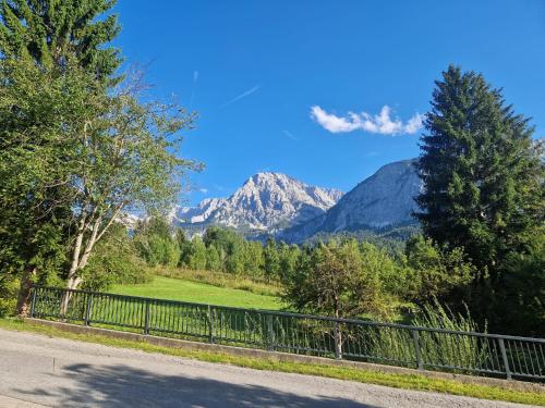 a road with a fence and mountains in the background at Sonnenburg Hotel in Ehrwald
