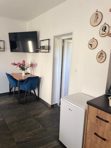 a kitchen and dining room with a table and blue chairs at Bellas apartmani in Novi Sad