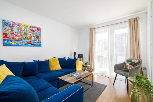 a blue couch in a living room with a table at Modern Retreat - 3 Beds - Parking - Wifi - 15 mins to tube in London
