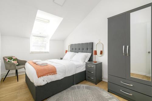 a bedroom with a large bed and a chair at Modern Retreat - 3 Beds - Parking - Wifi - 15 mins to tube in London