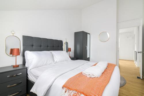 a bedroom with a large bed with a black headboard at Modern Retreat - 3 Beds - Parking - Wifi - 15 mins to tube in London