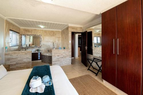 Habitación grande con cama y baño. en Jeffreys Bay Beach Accommodation Waters Edge, en Jeffreys Bay