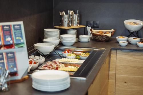a buffet with plates and food on a counter at Pension Gabl in Pfunds