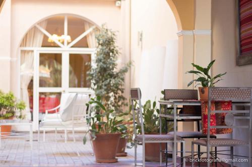 a patio with plants and a table and chairs at Delvino Boutique Hotel in Salta