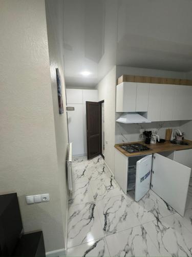 a kitchen with a marble floor and white cabinets at Tsikhisdziri in Ts'ikhisdziri