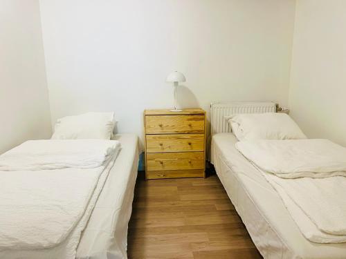 two twin beds in a room with a dresser at Comfortable room in Malmo- Husievägen 100 in Malmö