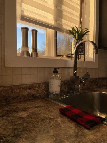 a kitchen counter with a sink and a window at Cottage de style Loft in Saint-Charles-des-Grondines
