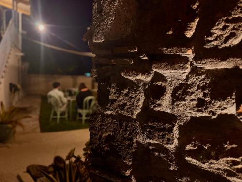 a brick wall with people sitting at a table at night at Cascina 1956 in Palestrina